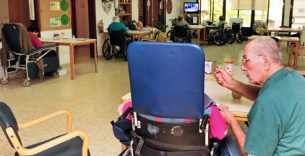 Elder feeding a nursing home patient