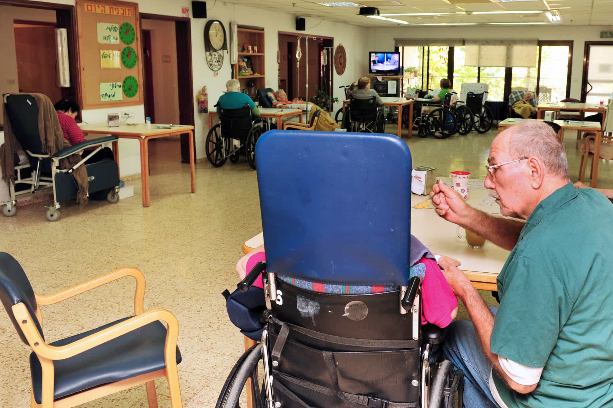 Elder feeding a nursing home patient